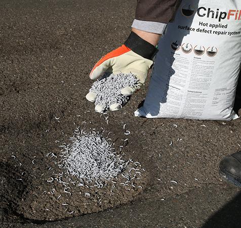 Chipfill verstreute Kupferstücke im Straßenloch